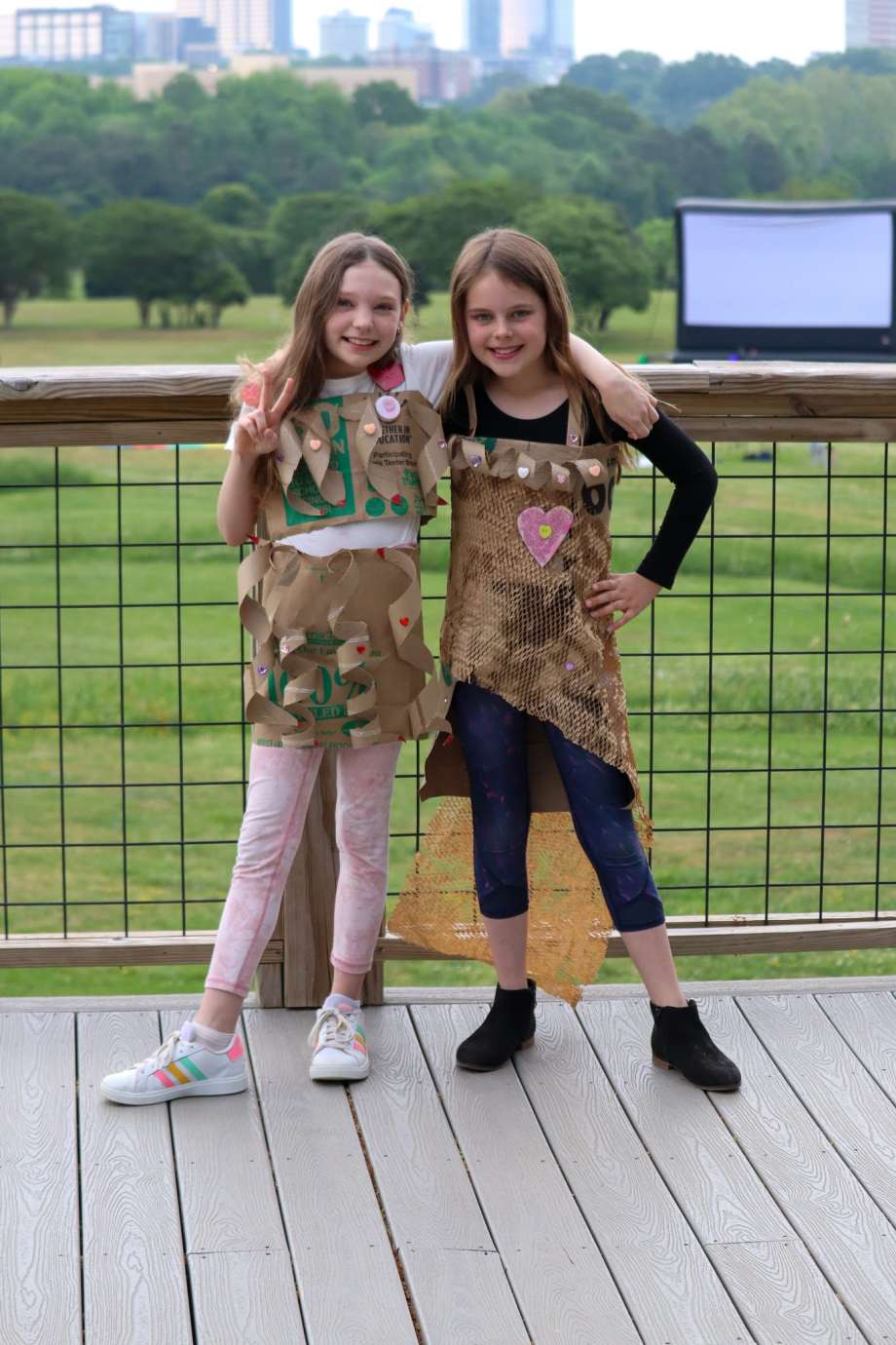 Two girls pose with their trashion outfits on