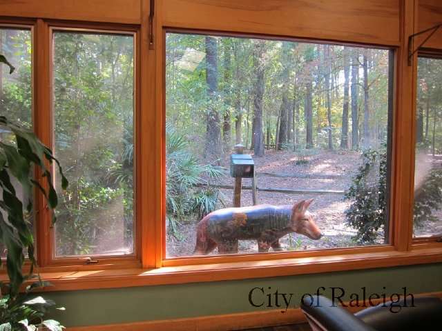 Outdoor wolf sculpture looking in a large window at Sertoma Arts Center. 