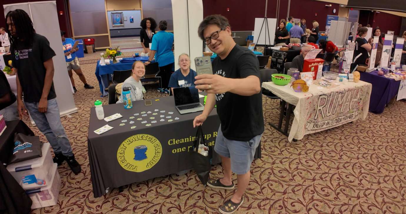 Gentleman takes selfie with a table in the expo hall