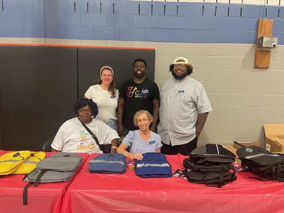 Members of Human Relations Commission smiling for photo behind table at community event