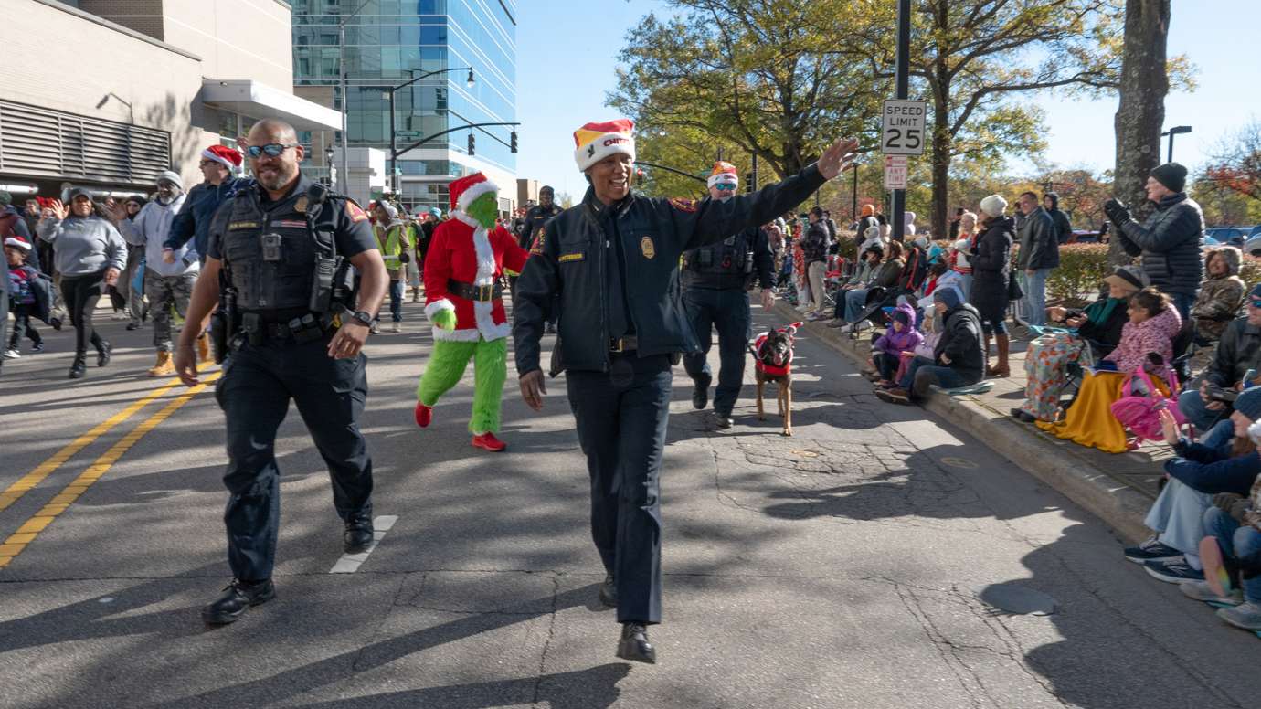 Raleigh Police Chief Estella Patterson along with another RPD officer waves to the crowd as they walk in the Christmas parade.