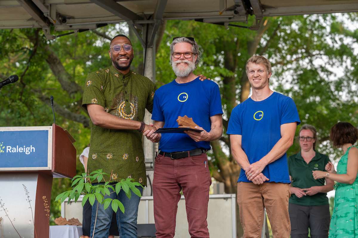 Environmental award winners accept a trophy. 