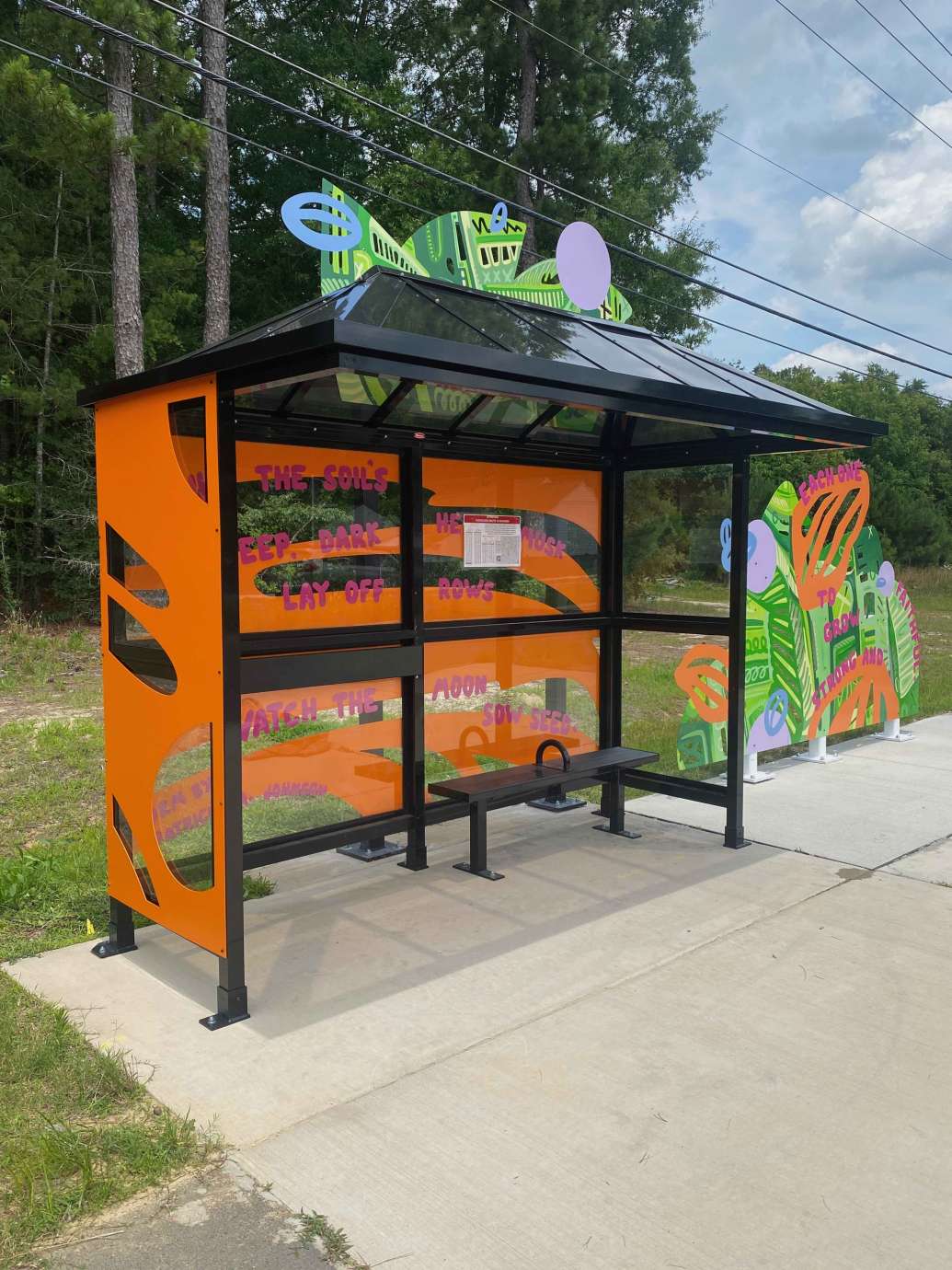 Colorful artwork installed behind and beside bus shelter