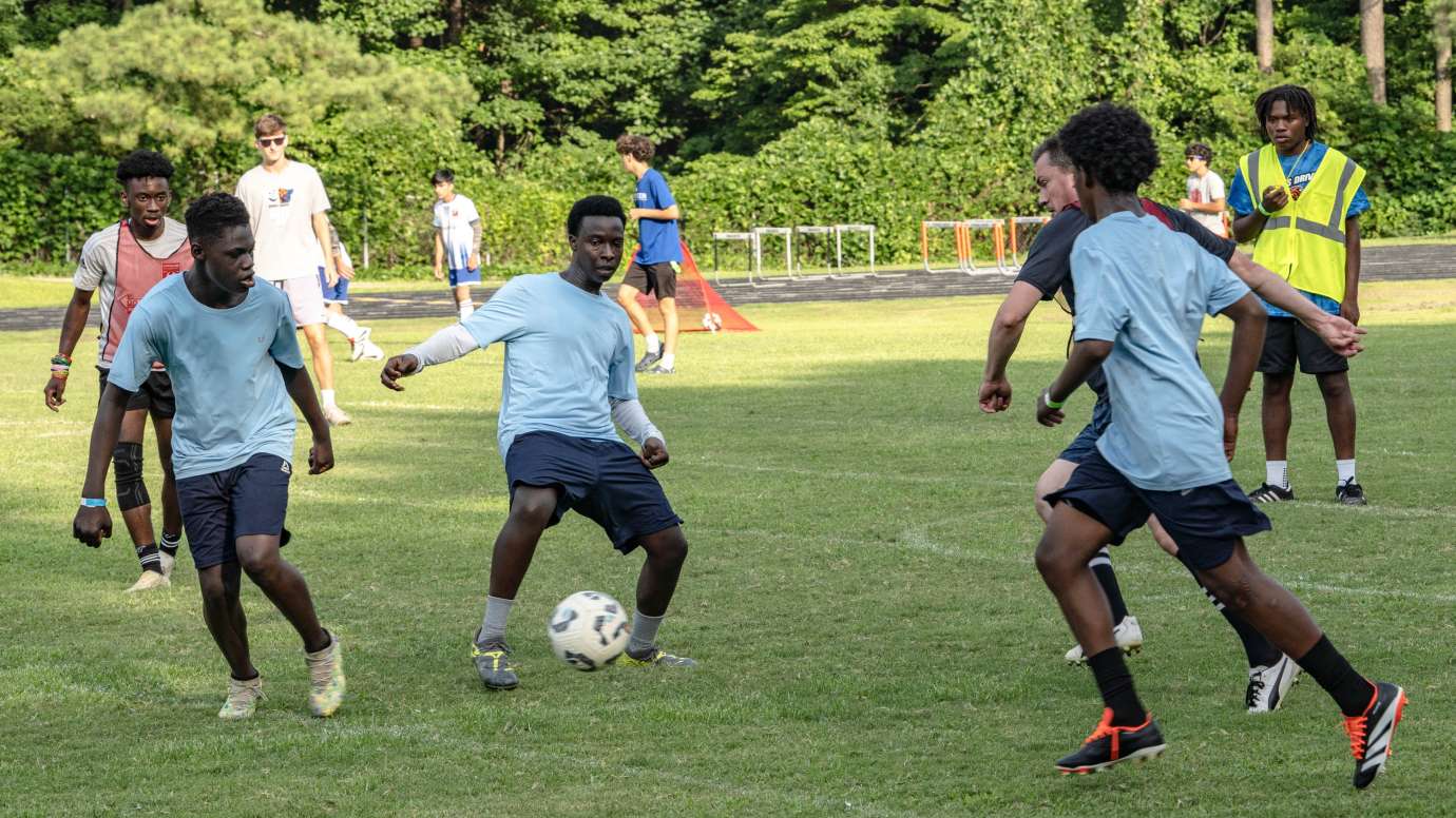 a group of young adults playing soccer outdoors