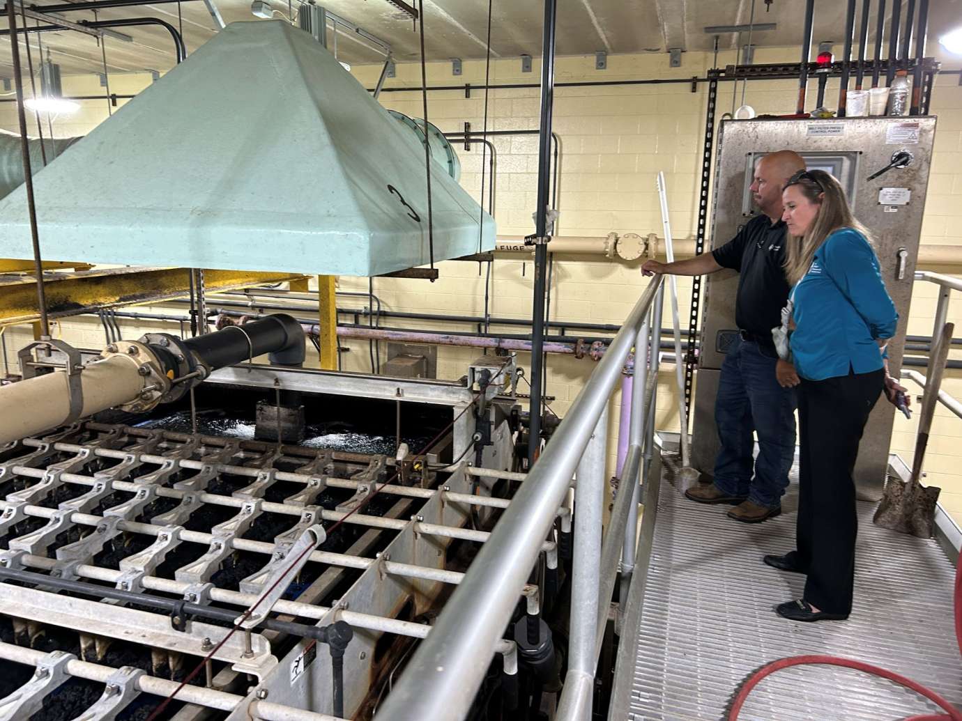 Workers looking at wastewater plant machinery