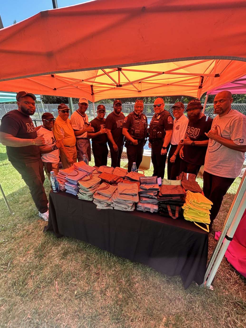 Community members and RPD officers standing under orange tent