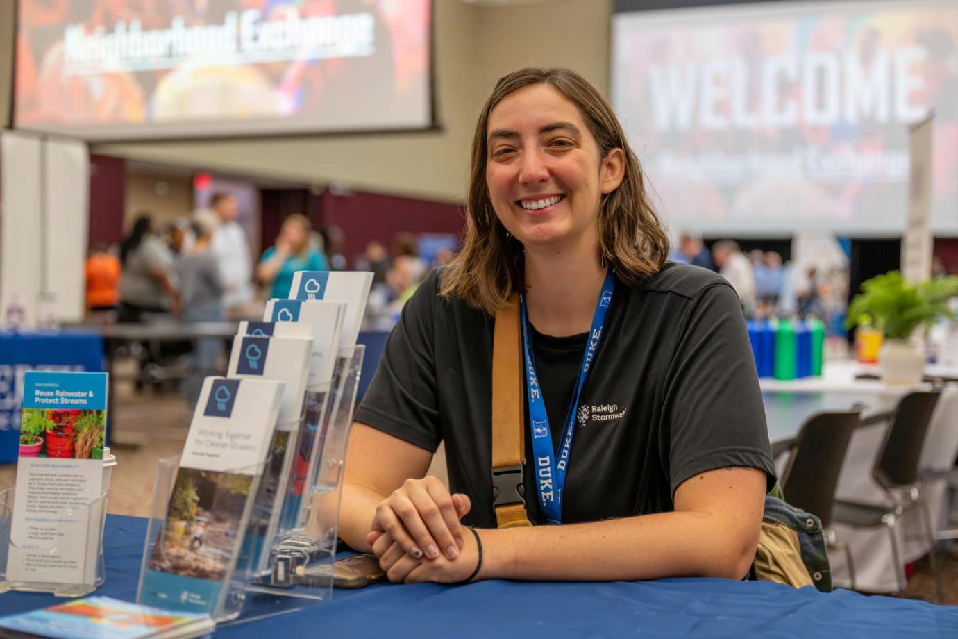 A woman sits behind a City of Raleigh table in the exhibit hall.