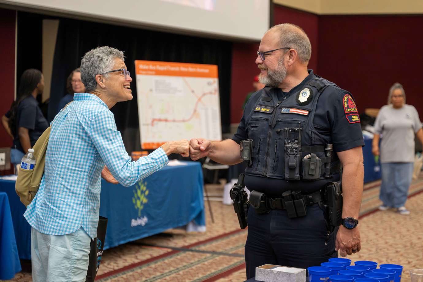 A Raleigh police officer fist bumps a resident passing their table
