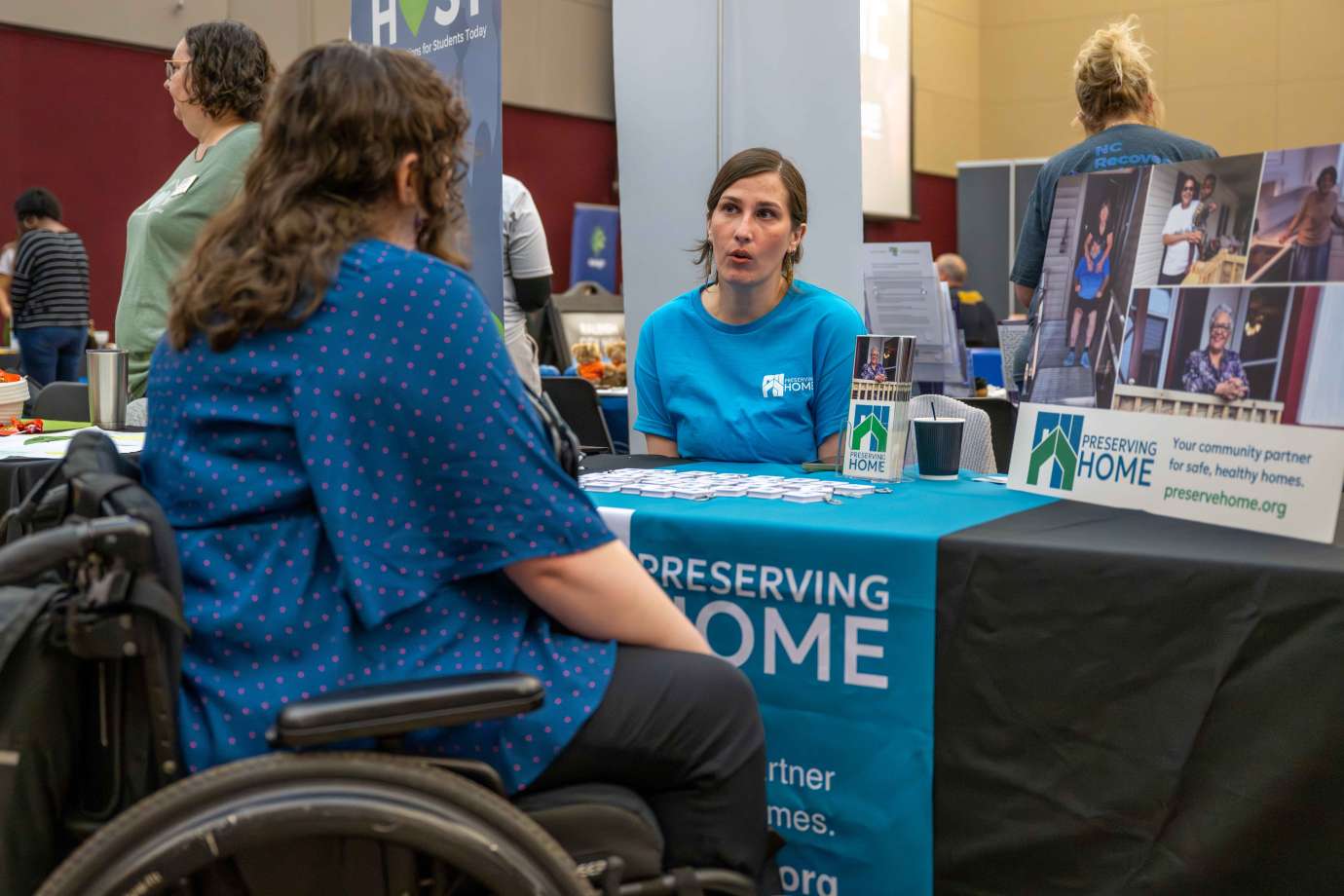 A woman with limited mobility talks to staff with Preserving Home