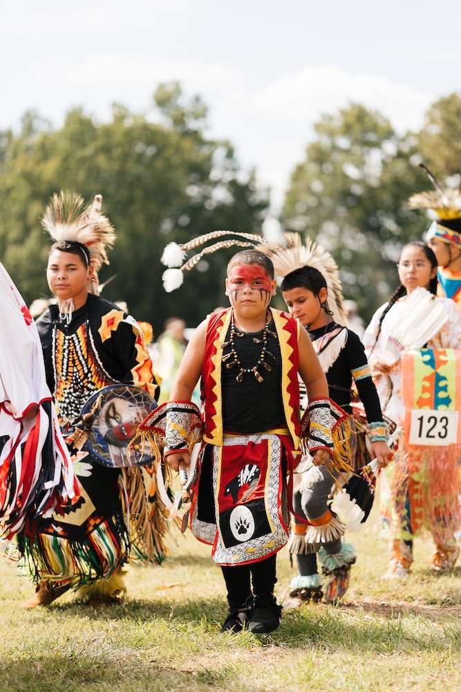 A photo of children dressed in ceremonial Native American clothing