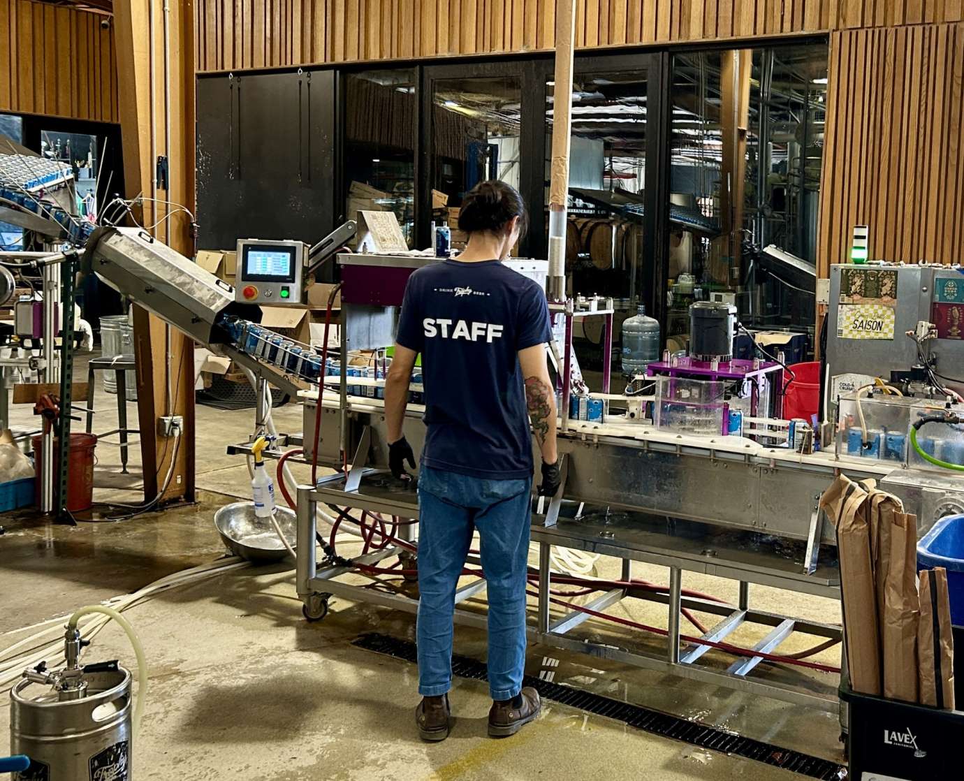 employee standing in front of a canning machine
