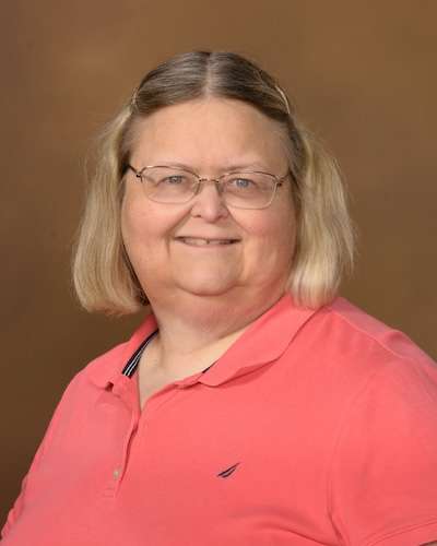 Headshot of Ginger Rush wearing a coral-colored shirt