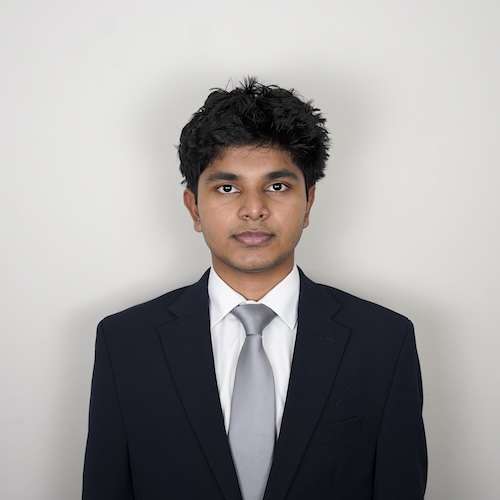 Headshot of Tharakeswaran Suresh wearing a suit and tie