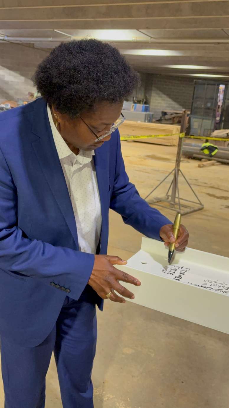 City Council member Stormie Forte, signing the top beam of City Hall 