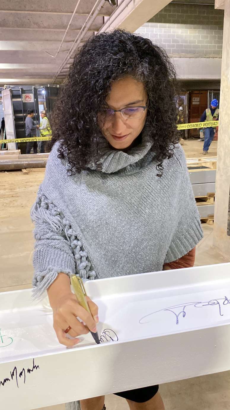 City Council member Christina Jones, signing the top beam of City Hall 