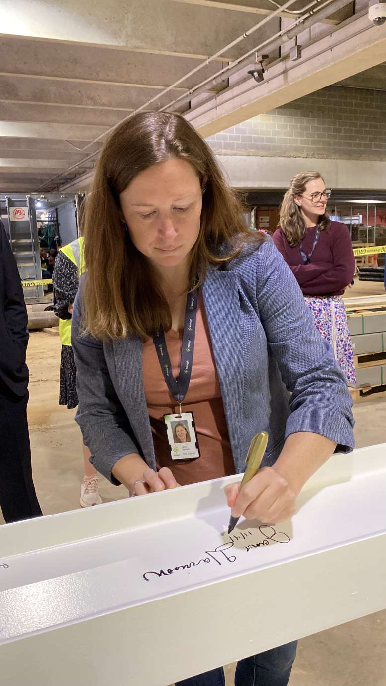 City Council member Jane Harrison, signing the top beam of City Hall 