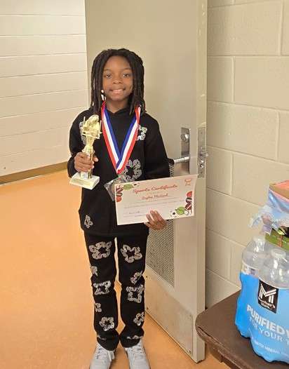 a boy holding an award