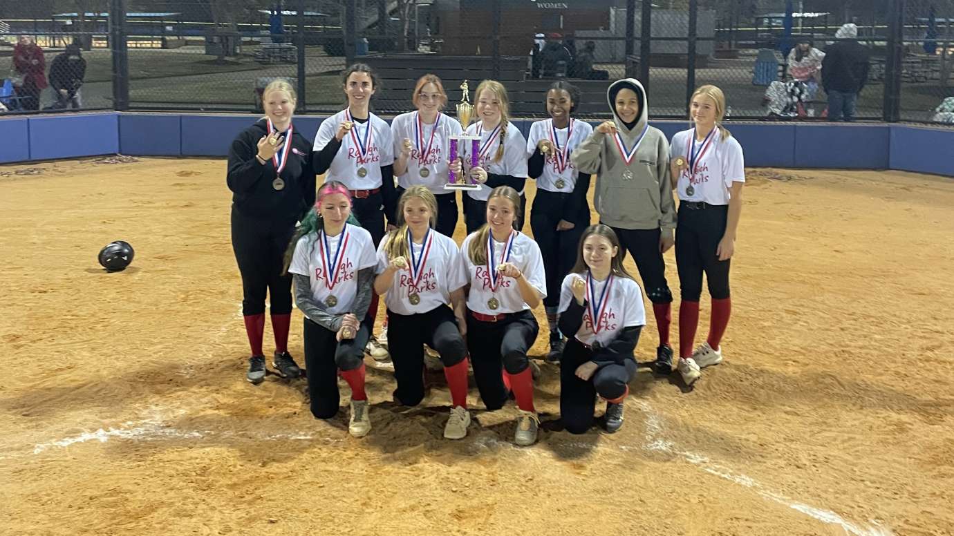 a group of girls winning champs for softball