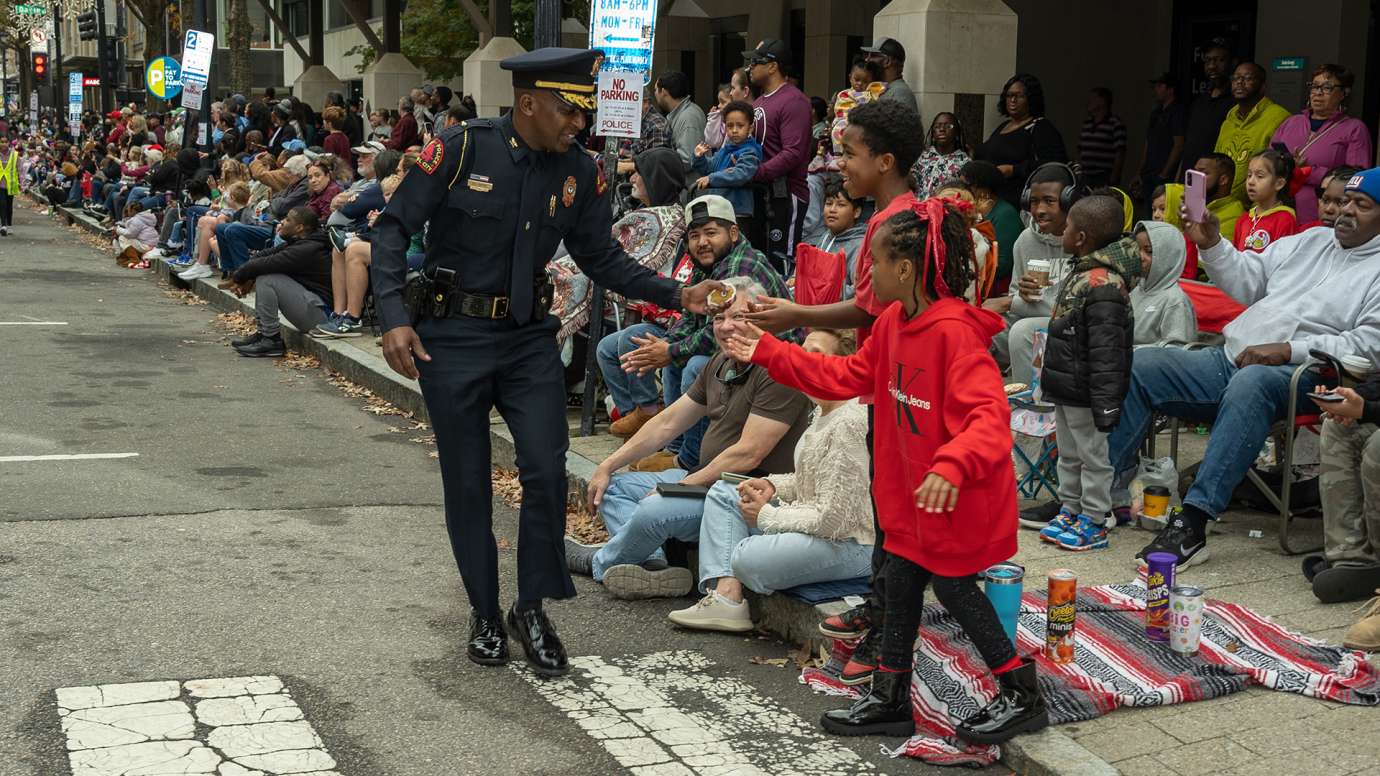 Chief Boyce handing out candy to children watching the Raleigh Christmas parade