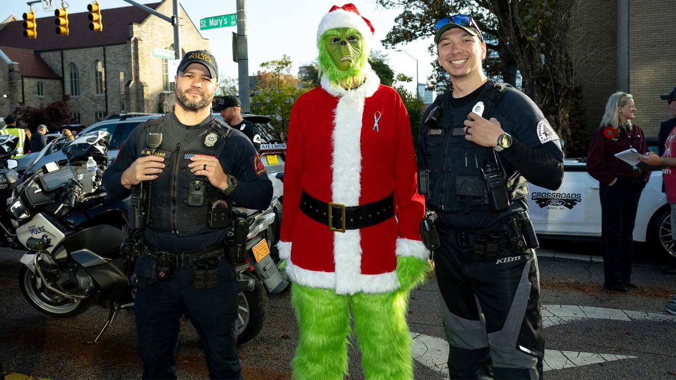 Two RPD officers with the Grinch at the Raleigh Christmas parade