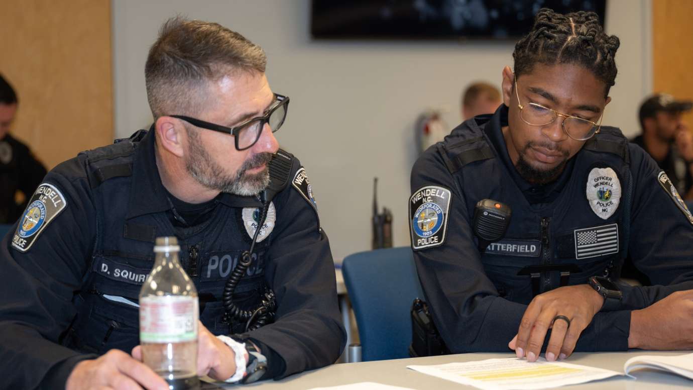 Two police officers looking at document on table