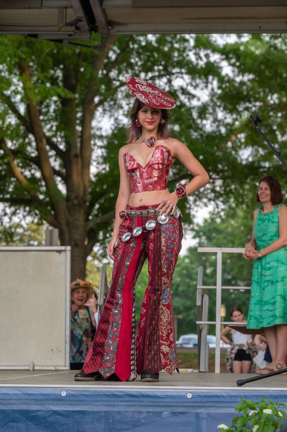 A woman poses on stage in an outfit made of recycled material.