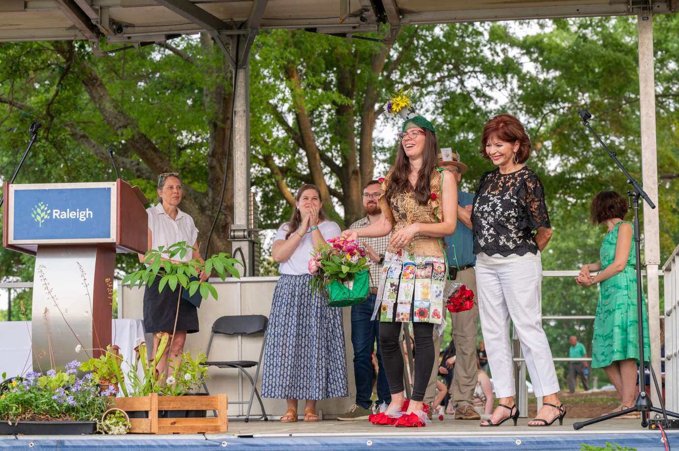 A woman poses on stage in an outfit made of recycled material.