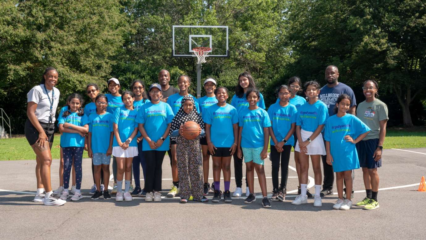 Police youth basketball team standing in front of net