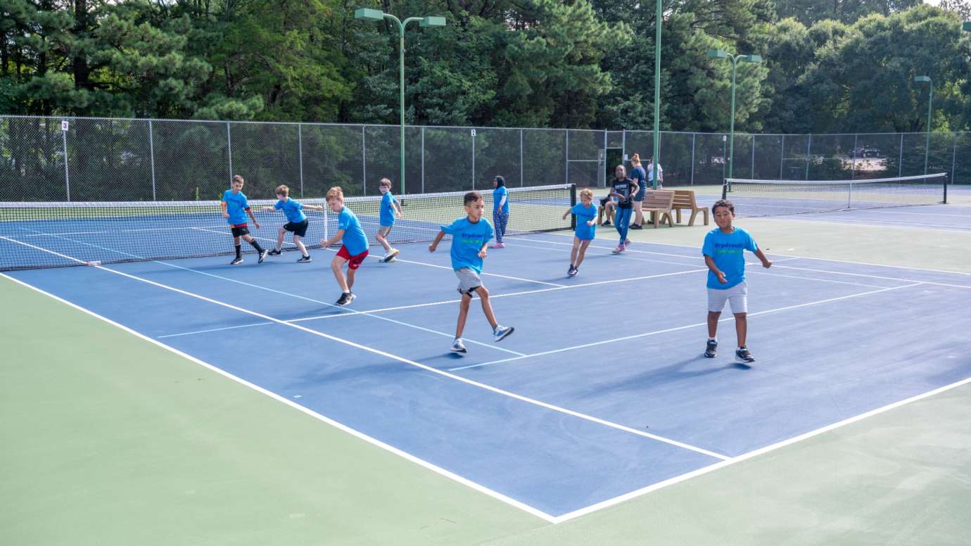 Youth tennis players running on court