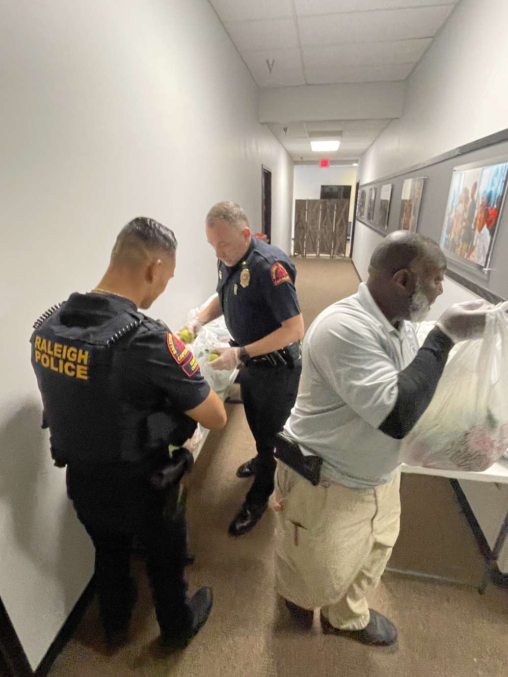 Two RPD officers holding a plastic trash bag