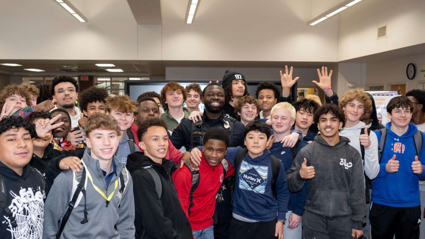 Students and police officer smiling