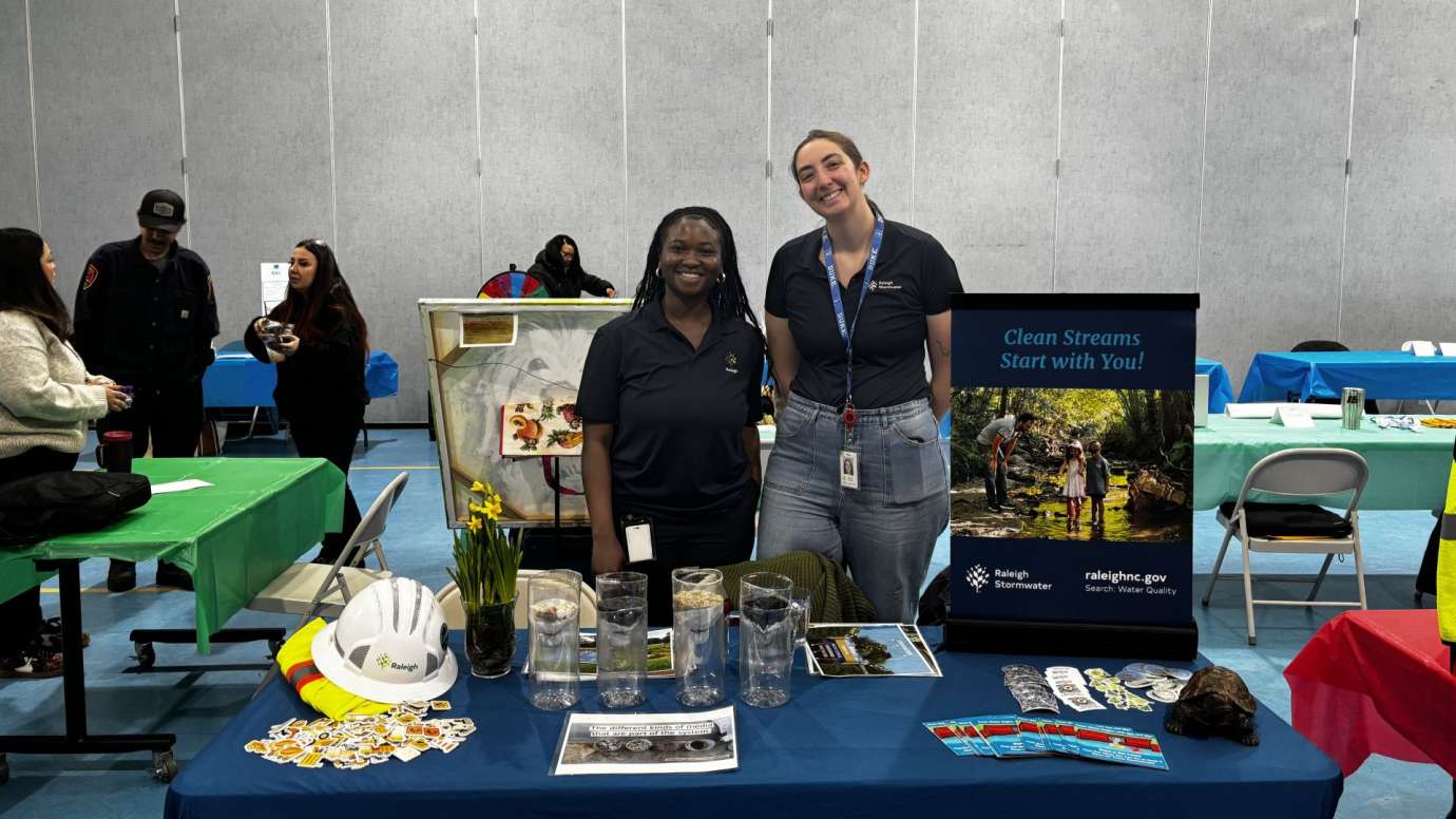 two women smiling behind table
