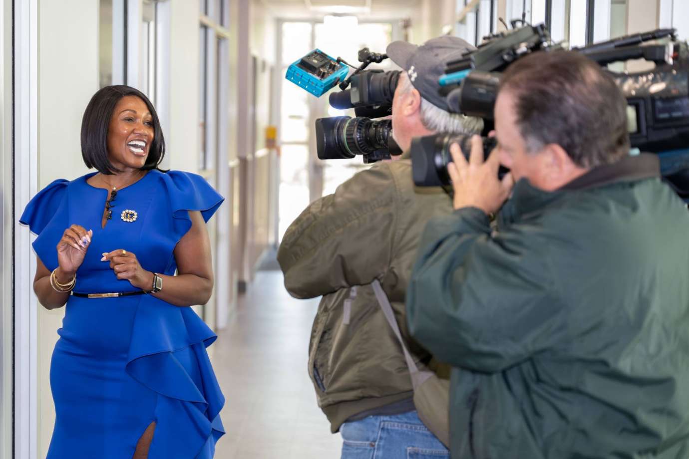Worker interviewed at lab ribbon cutting in front of cameras