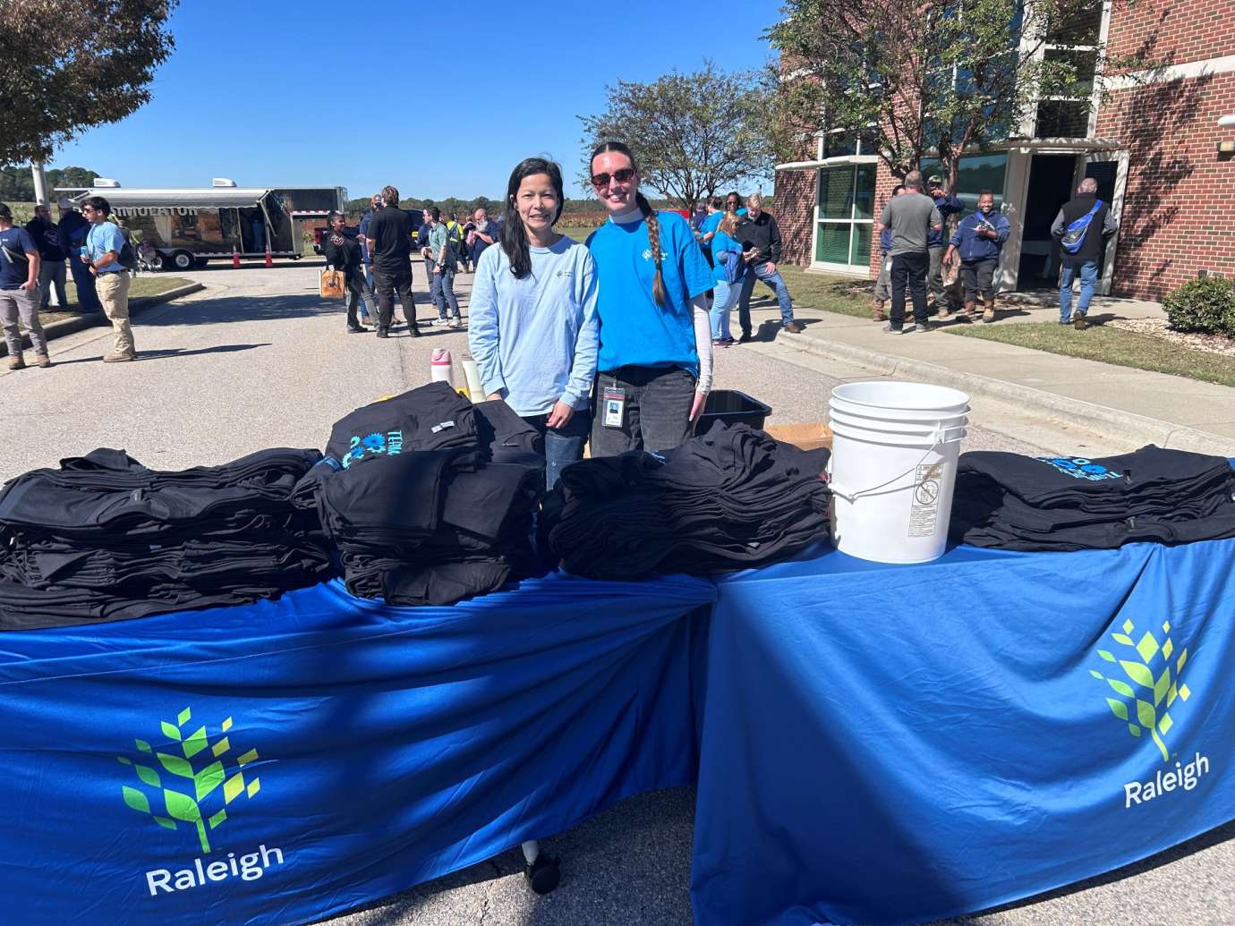 Workers standing at table handing out shirts