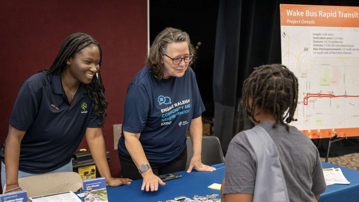 two women smiling behind table with a kid
