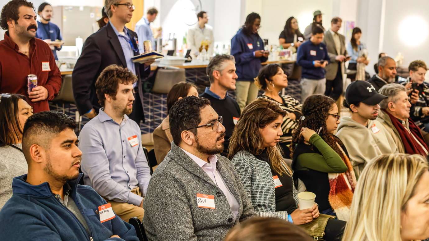 a group of people listening to a presenter 