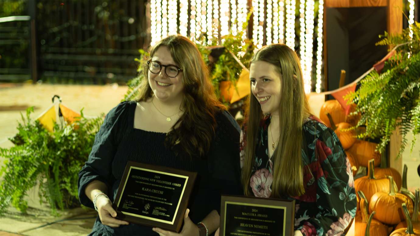two people holding award plaques while smiling