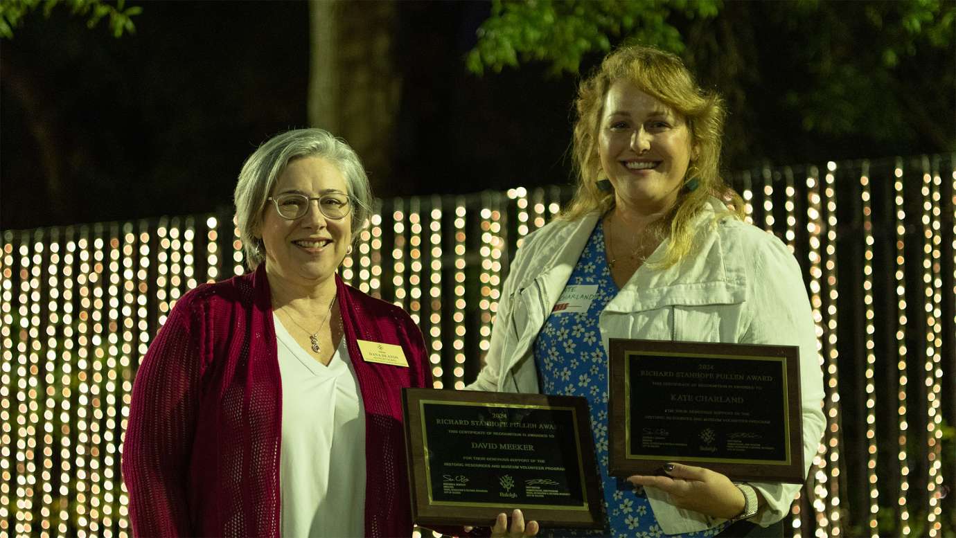 two people holding award plaques while smiling