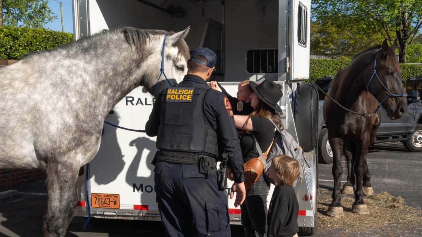 Police officer leads horse to child