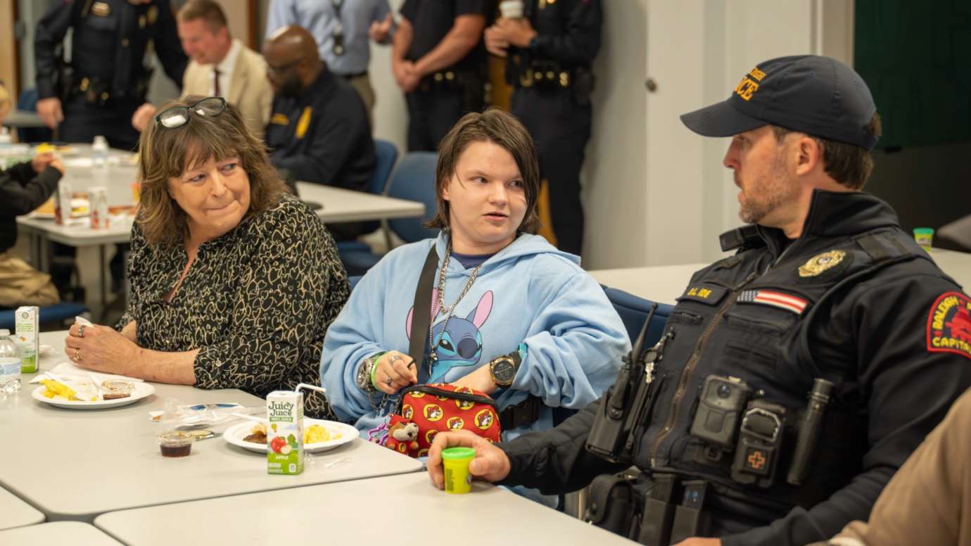Police officer sitting at table with child 