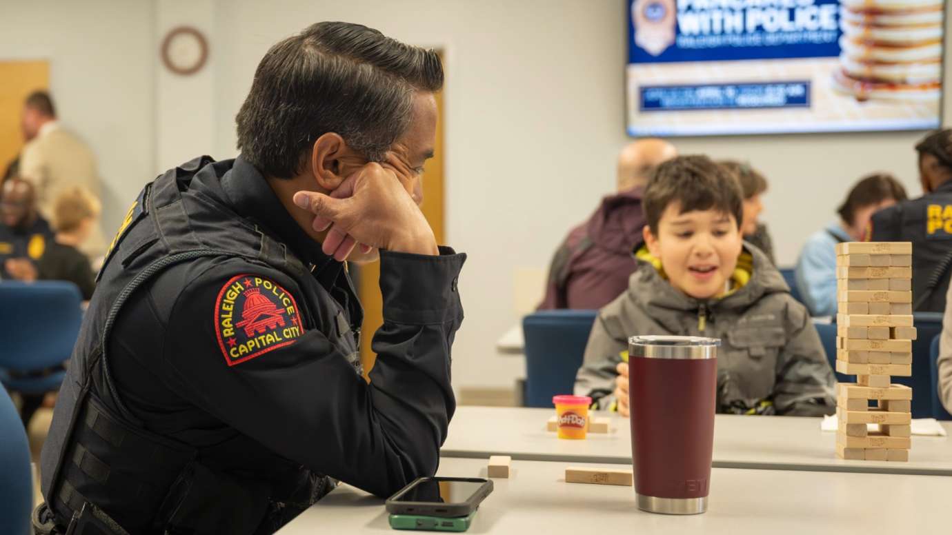 Police officer stacking blocks with child