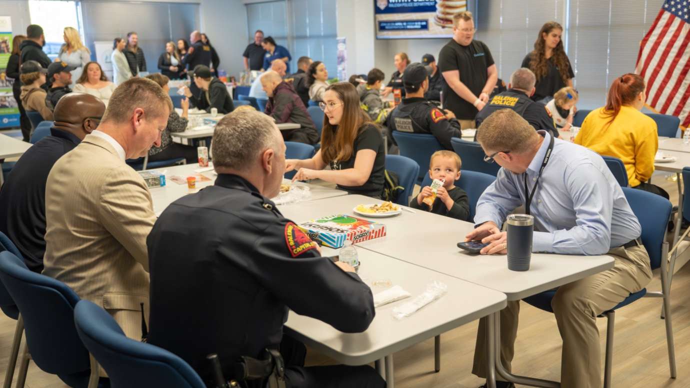 Police officers sit at table with community members