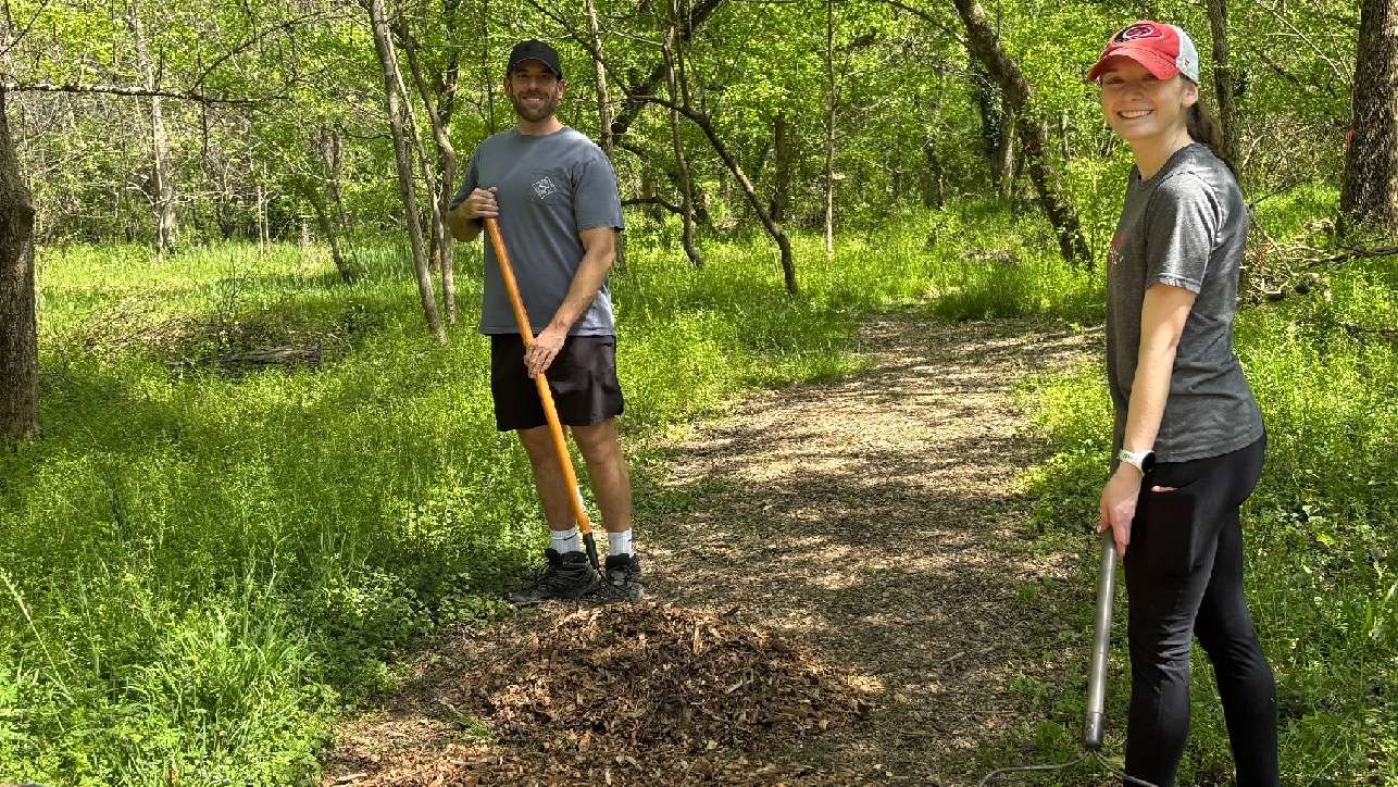 volunteers adding mulch to a path