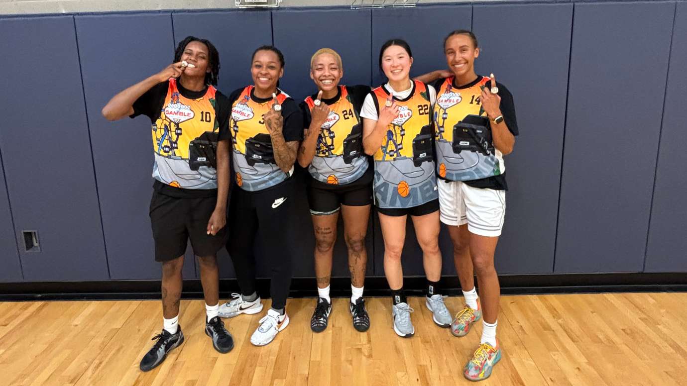 the women's league basketball champions with 5 teammates smiling