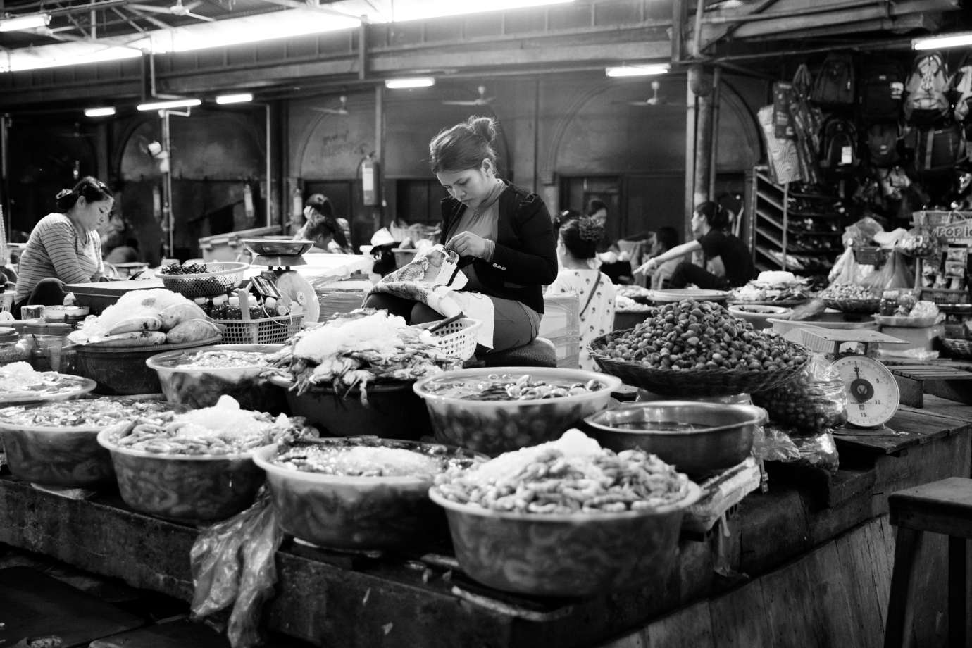 Black and white photograph of farmer's market vendor sewing