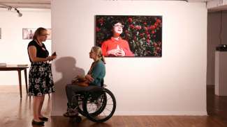 two people talking in wheel chair accessible art gallery