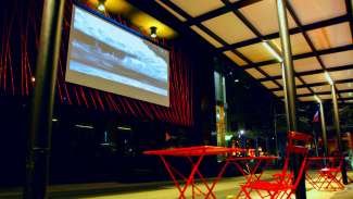 table in chairs in front of the Block2 Gallery screen in Market Plaza