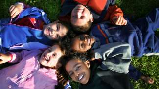 Diverse group of kids laying on the grass