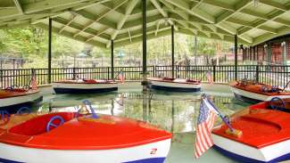 view of six empty kiddie boats floating under the pavilion at pullen park
