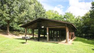 picnic shelter with a fireplace, tables and charcoal grill